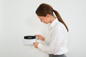 woman activating home thermostat