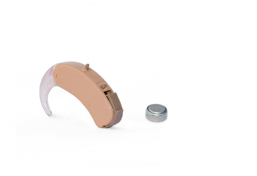 A hearing aid and a battery on a white background