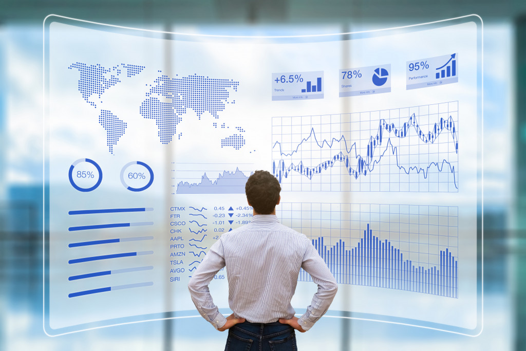 A businessman looking at performance data on a digital screen